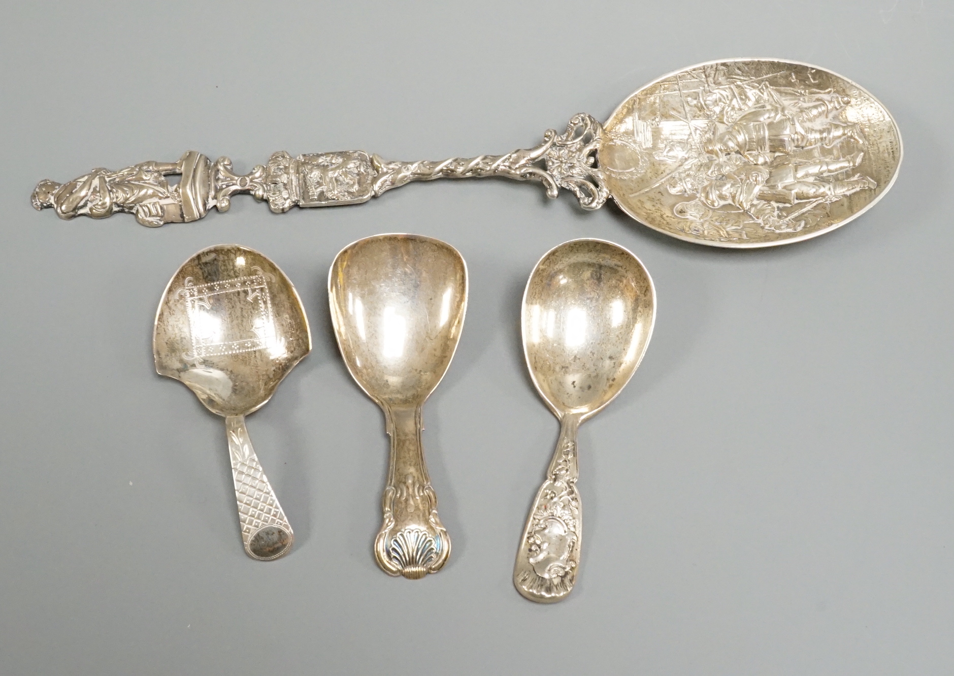 Two 19th century silver caddy spoons, including Birmingham, 1827, one later caddy spoon and an ornate Dutch white metal serving spoon.